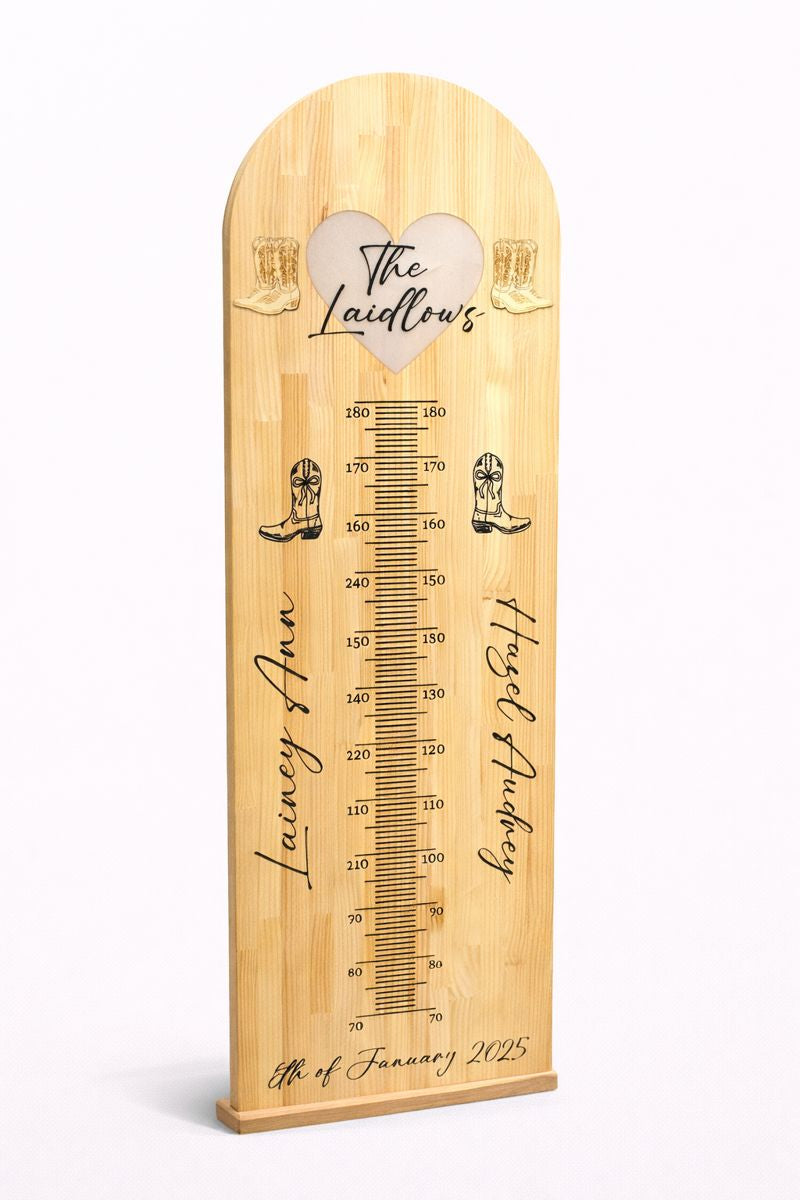Personalised wooden height chart board with names and measurement markings.