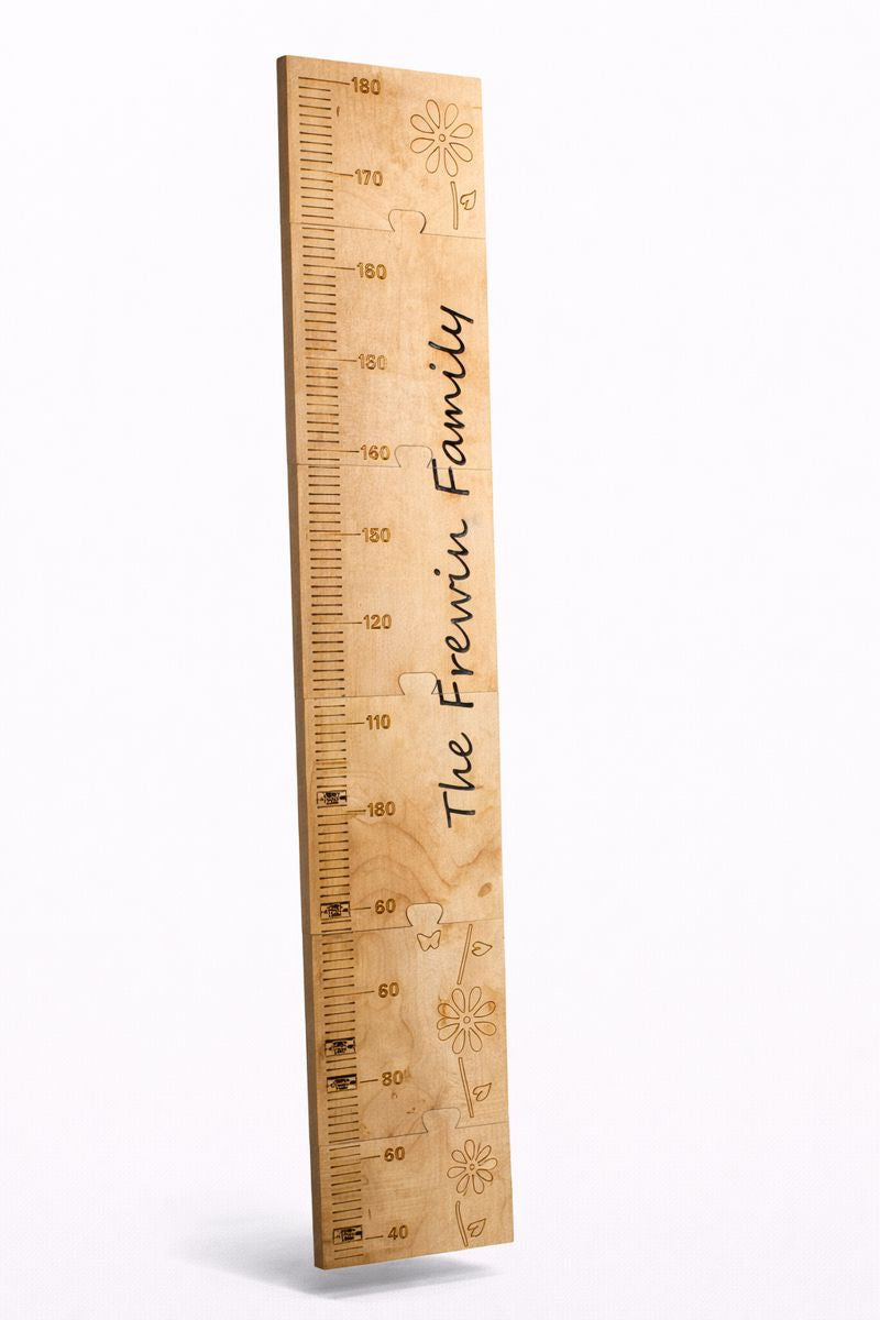 Personalised wooden height chart ruler with measurement markings and family name.