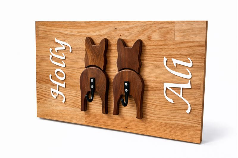 Personalised wooden plaque with dog tail hooks and engraved names “Holly” and “Ali.”