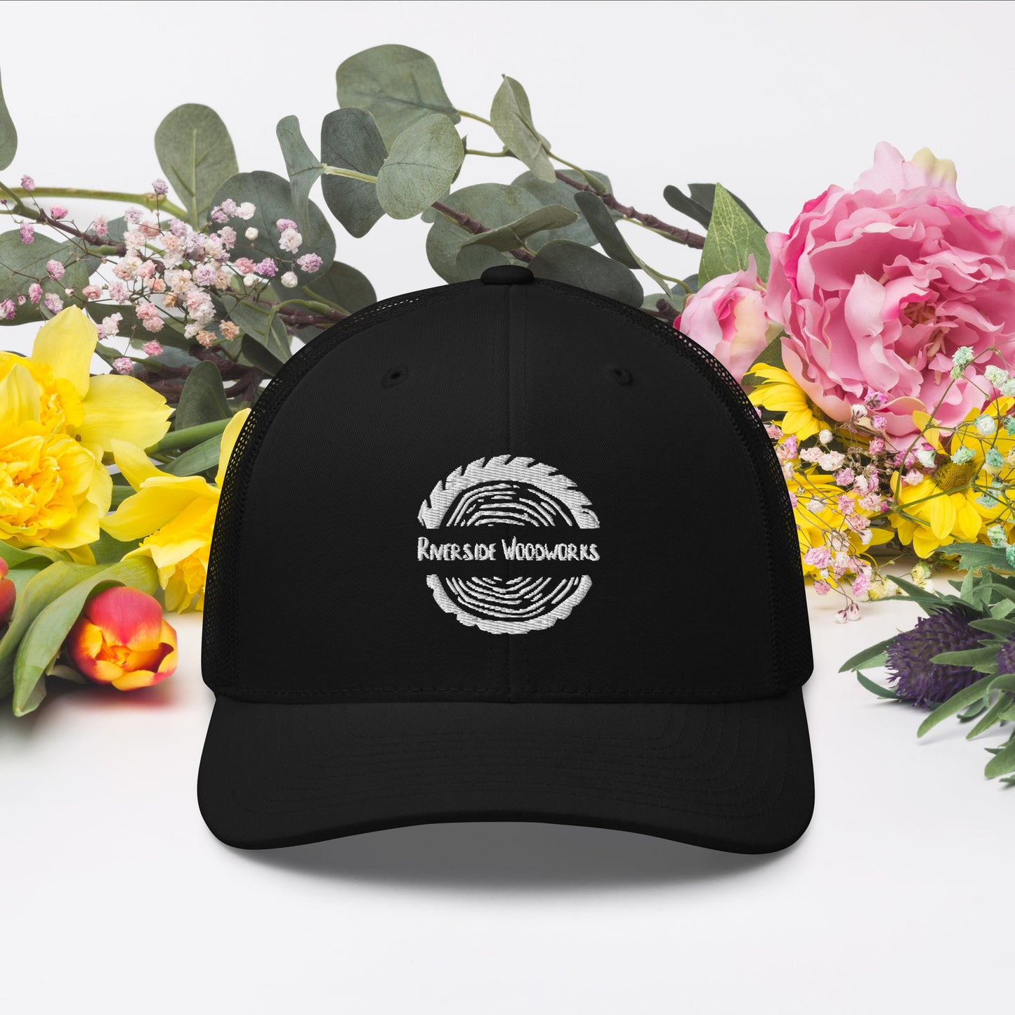Black trucker cap with white logo featuring structured front panels and mesh back
