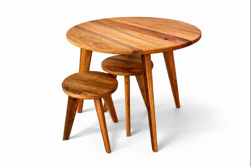 Round wooden table accompanied by matching nested stools.