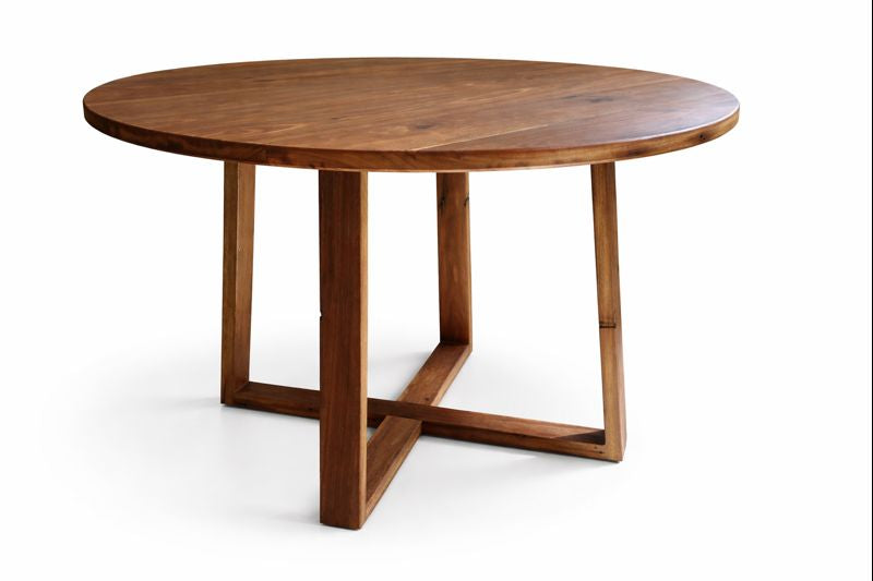 Round wooden dining table with cross‑trestle pedestal base.