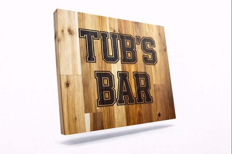 Custom wooden sign engraved with the text “TUB’S BAR” in bold block letters.