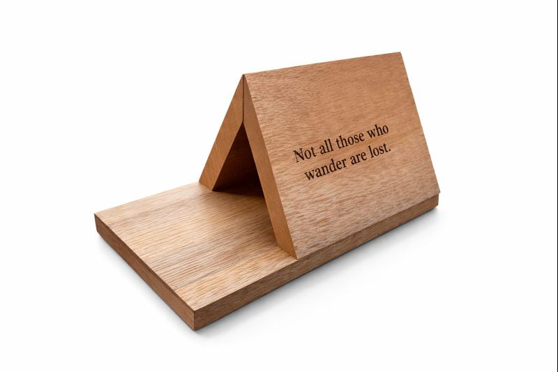 Folding wooden stand for books or devices engraved with “Not all those who wander are lost.”